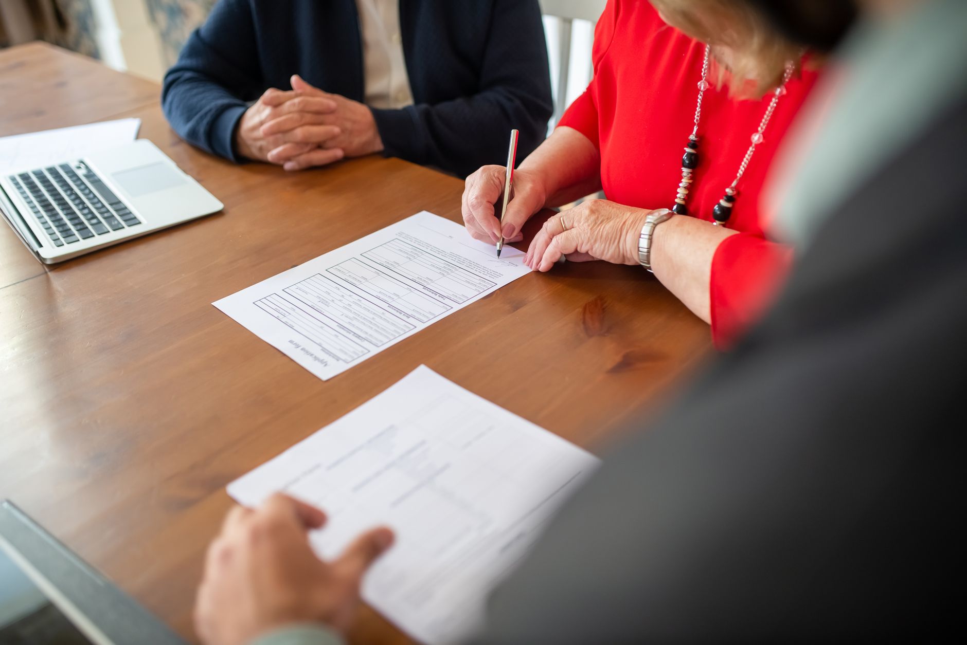 Person reviewing and signing mortgage loan documents at a desk