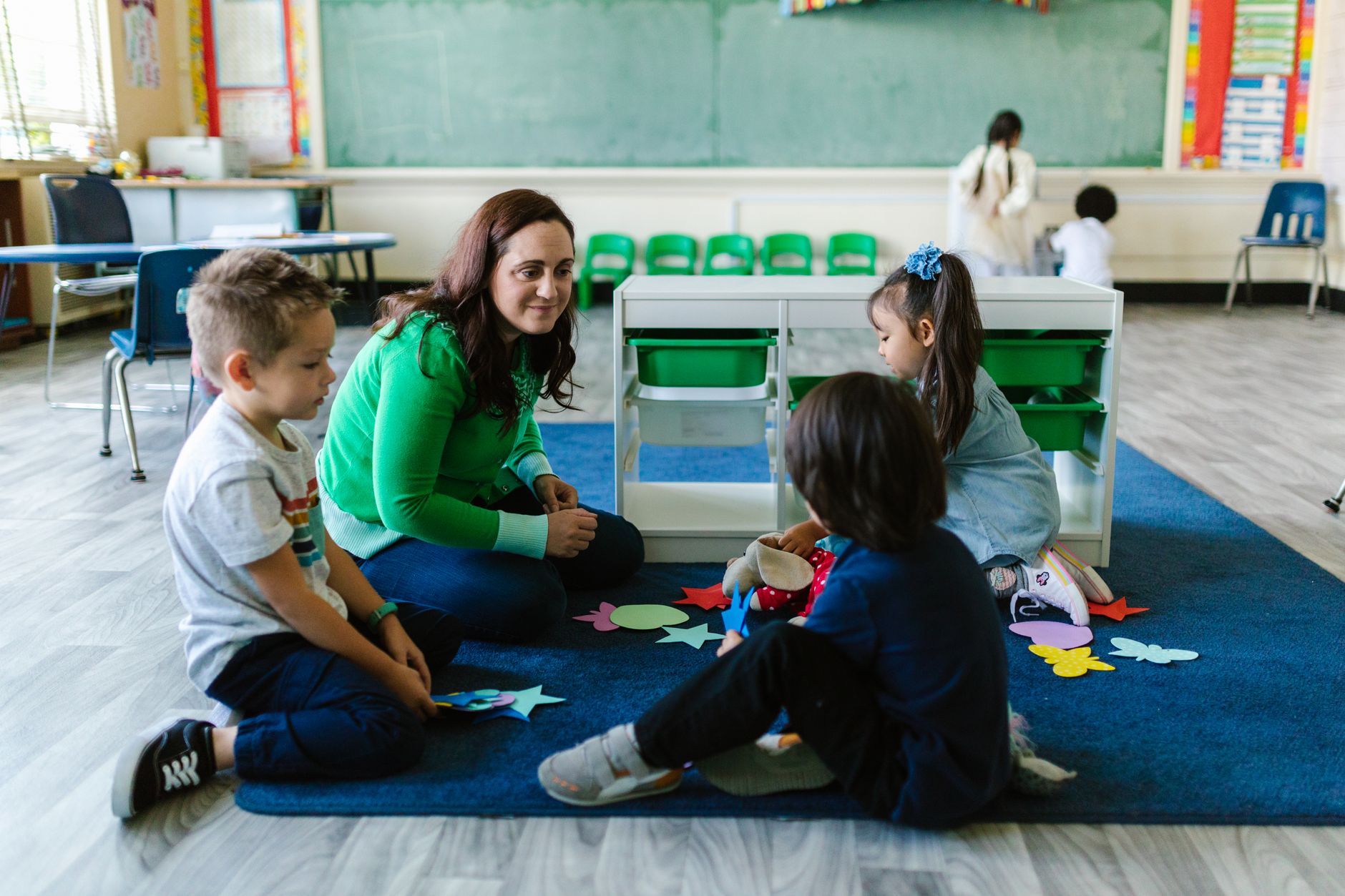 Children at a daycare center with a caregiver in a bright indoor setting
