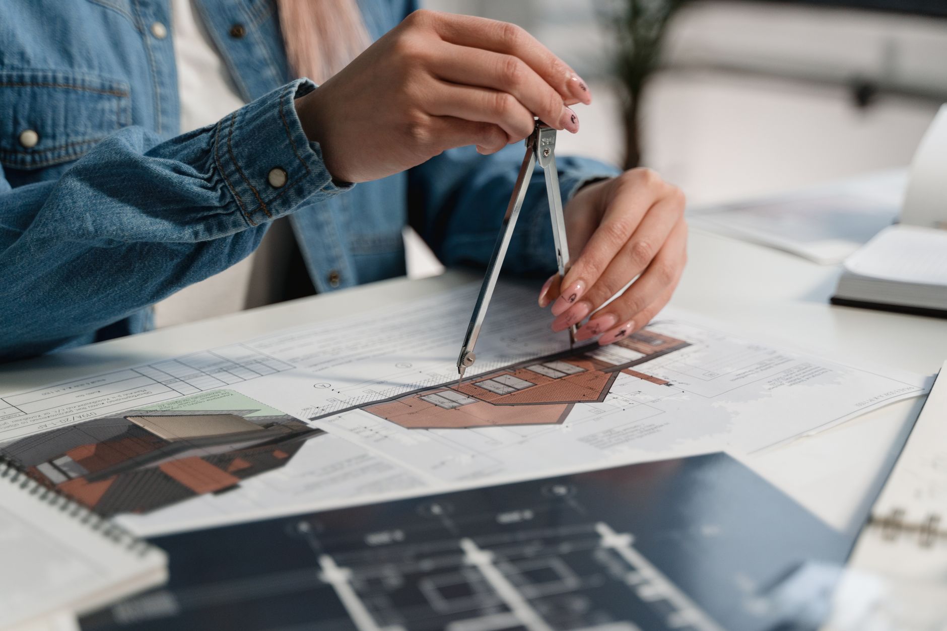 Architect reviewing housing development blueprints at a desk with planning documents spread out