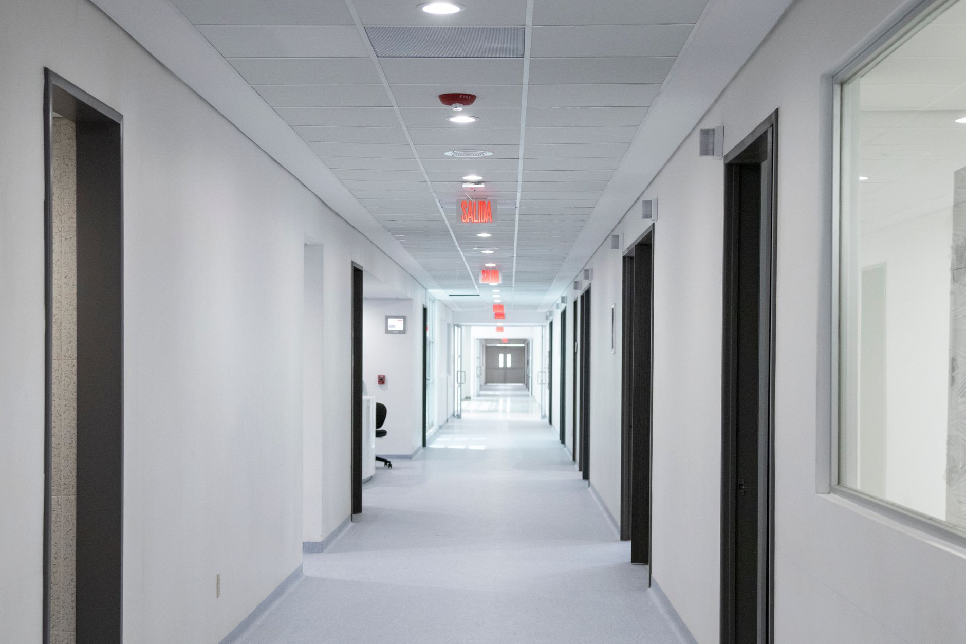 A quiet, dimly lit hospital hallway suggesting reduced activity or financial strain
